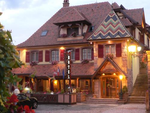 a large house with a gambrel roof at Hôtel Le Mittelwihr in Mittelwihr