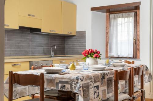 una cocina con una mesa con platos y flores. en Feel at Home - VILLA VERBENA, en Monasterolo del Castello
