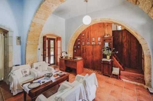 a living room with white furniture and an archway at Iconic Cretan Stone Mansion in Kambánion