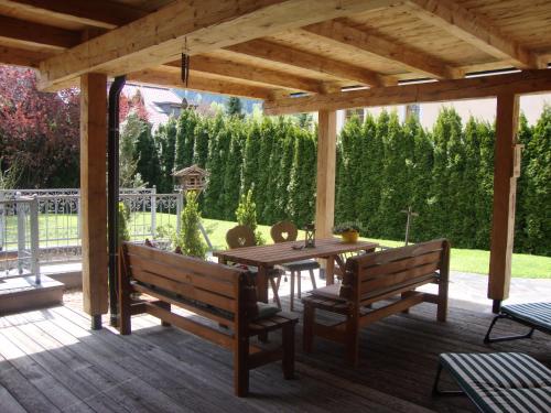 a wooden pergola with a table and benches on a deck at Haus Andreas in Kitzbühel