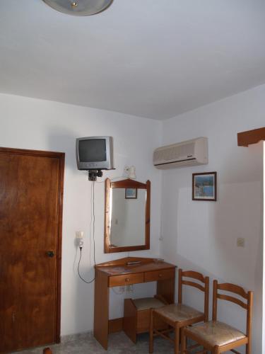 a room with a vanity and a mirror and a tv at Roses Studios in Karpathos Town