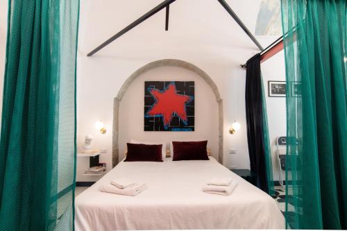 una camera da letto con un letto bianco con due asciugamani di Balloon Design Studio Apartment a Molfetta