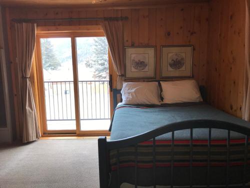 a bedroom with a bed in front of a window at The Lodge at Red River in Red River