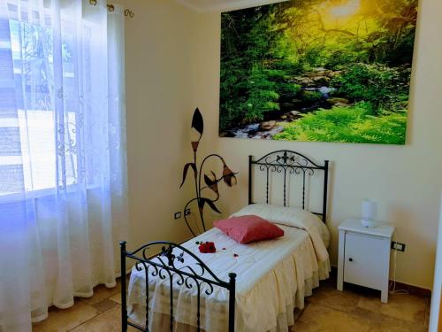 Schlafzimmer mit einem Bett mit Wandgemälde in der Unterkunft Villa dei Glicini in Parabita