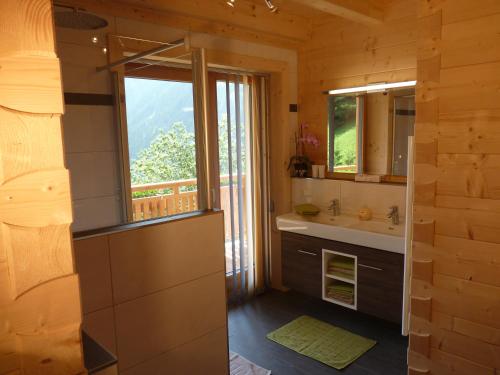 ein Bad mit einem Waschbecken und einem Fenster in der Unterkunft Chalet Rasnerhof in Hopfgarten in Defereggen