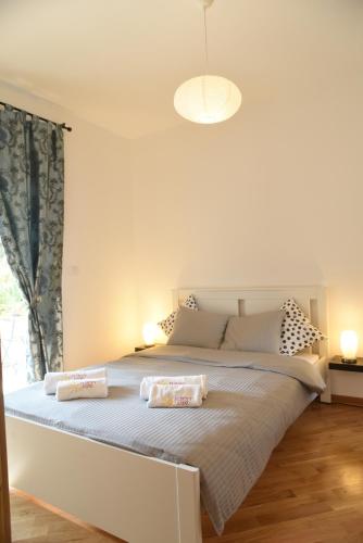 a bedroom with a large bed with two pillows on it at Apartmani Sunny side sa otvorenim bazenom-besplatan parking in Vrnjačka Banja