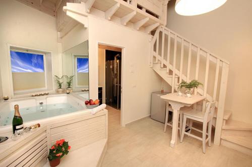 uma casa de banho com uma banheira, uma mesa e uma escada em lavelo לה ולו em Safed