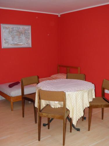 Pokój ze stołem i krzesłami oraz czerwoną ścianą w obiekcie Marianki w mieście Dąbrowa Górnicza