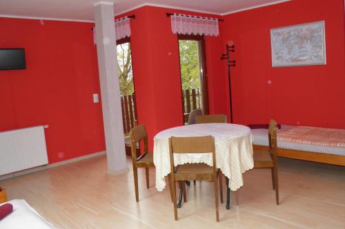 棟布羅瓦古爾尼恰的住宿－Marianki，一间拥有红色墙壁和桌椅的用餐室