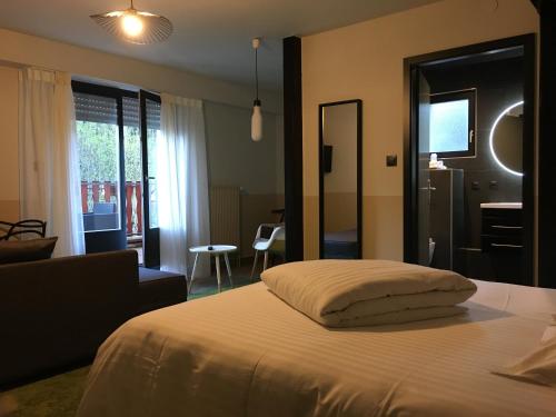 a bedroom with a bed and a living room at Hotel Restaurant au Floridor in Thann