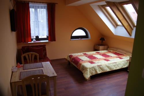 a bedroom with a bed and a table and windows at Domowe Zacisze in Ustka