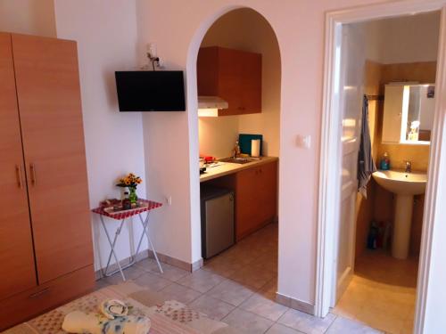 a kitchen with an archway in the middle of a room at Larinaki's Studios No3 in Amorgos