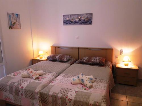 two beds in a small room with two lamps at Larinaki's Studios No3 in Amorgos