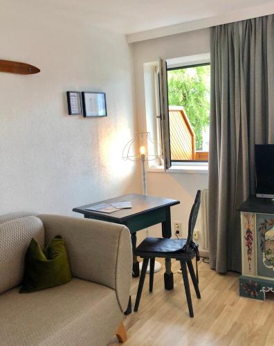 a living room with a couch and a table and a window at Hotel Sonnenhof - bed & breakfast & appartements in Innsbruck