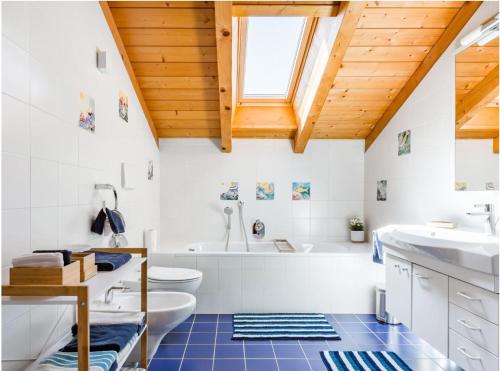 a bathroom with a white tub and a sink at Lions Apartments in Völs am Schlern