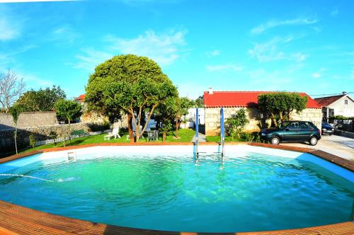 ein großer Pool mit Wasser in einem Hof mit Auto in der Unterkunft Quinta dos Avós in Viana do Castelo