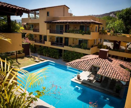 ein Wohnhaus mit einem davorliegenden Swimmingpool in der Unterkunft Los Mangos in Zihuatanejo