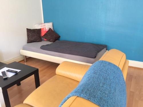 Habitación con cama, sofá y silla en L'Appart Bleu - Lumineux F3 Mulhouse Gare/Centre, en Mulhouse