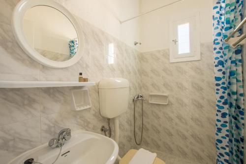 a bathroom with a toilet and a sink and a mirror at Aliki Panorama Rooms in Aliki