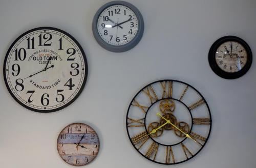 un grupo de relojes en una pared blanca en The Olive Green House, en Burgas