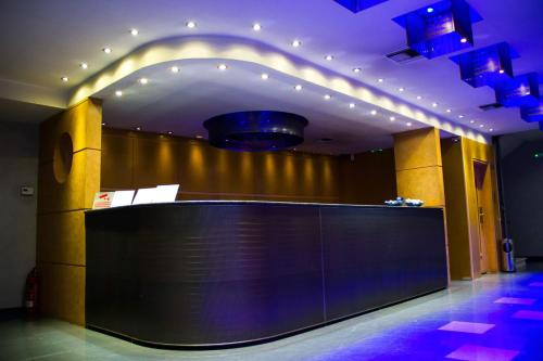 a lobby with a black counter in a room with lights at Olympic Hotel in Piraeus