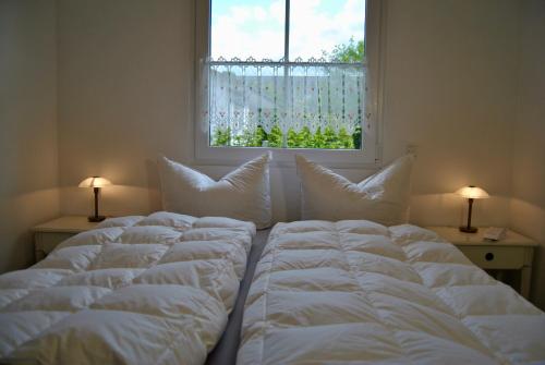 a bedroom with three beds in front of a window at Ferienhaus Berlin in Blankenfelde