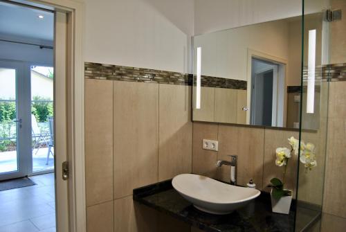 a bathroom with a sink and a mirror at Ferienhaus Berlin in Blankenfelde