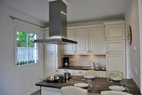 a kitchen with white cabinets and a sink and a stove at Ferienhaus Berlin in Blankenfelde