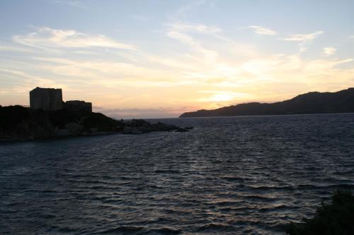 a large body of water with a castle in the distance at Verdemare Sardegna Uno in Villasimius