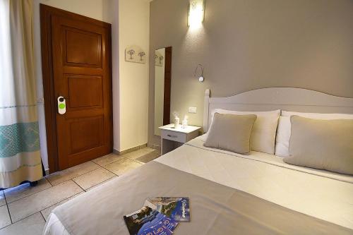 a bedroom with a bed and a door and a table at Hotel I Graniti in Villasimius