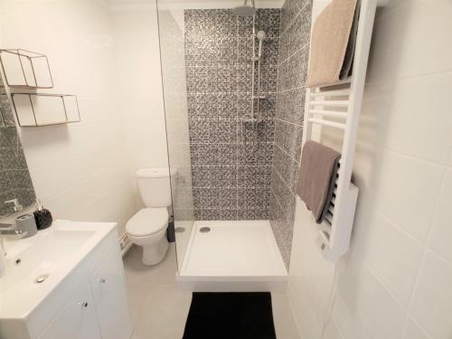a white bathroom with a toilet and a shower at Au 36, Les Apparts Hotel Joigny in Joigny