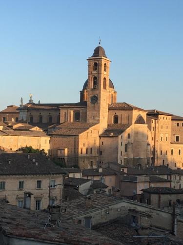 een groot gebouw met een klokkentoren in een stad bij Casa Nella in Urbino