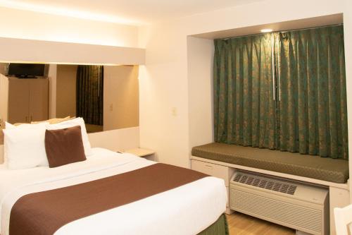 a hotel room with a bed and a window at Microtel Inn & Suites Lodi in Lodi