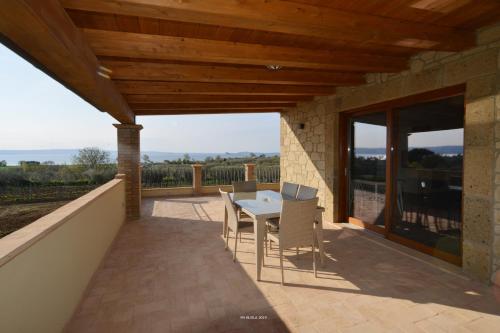 a patio with a table and chairs on a balcony at Il Casale degli Ulivi in Gradoli
