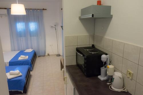 una piccola camera con due letti e una camera con una camera di Polykratis Rooms a Città di Skiathos