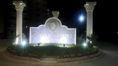 a sign for the casonar resort and spa at night at Angel's Apartment at Caesar Resort in Trikomo