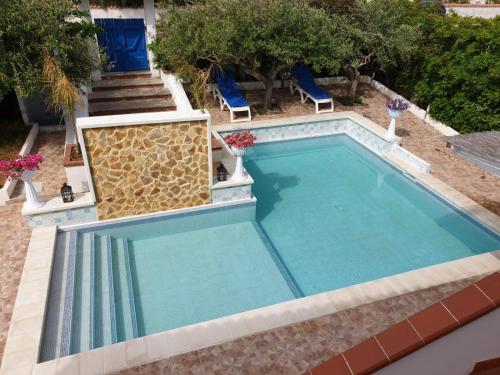 a large swimming pool with chairs and trees at Anastasia Villas-B&B in Lido Signorino
