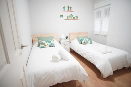 ビルバオにあるCoqueto junto a Casco Viejoのベッドルーム1室(白と青の枕が備わるベッド2台付)