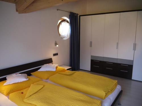 カンポ・トゥーレスにあるHörtmairhofのベッドルーム1室(黄色いシーツを使用したベッド2台付)