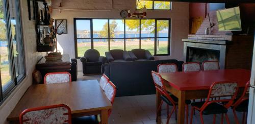 ein Wohnzimmer mit einem Sofa, einem Tisch und Stühlen in der Unterkunft Las Lomas Del Nihuil in El Nihuil