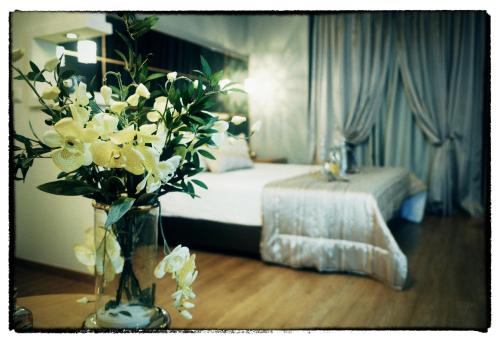 a bedroom with a bed and a vase of flowers on a table at Kristonia Hotel Suites in Kilkís