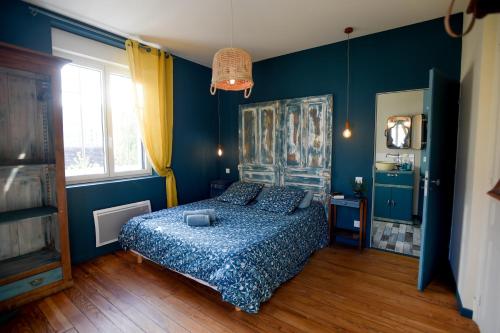 a bedroom with blue walls and a bed with a blue bedspread at L'EN VERT in Bagnères-de-Bigorre