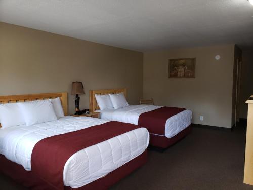 two beds in a hotel room with two beds sidx sidx sidx at Woodside Dells Hotel & Suites in Wisconsin Dells