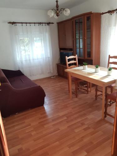 ein Wohnzimmer mit einem Tisch und einem Sofa in der Unterkunft Apartmani Čempres Senj in Senj