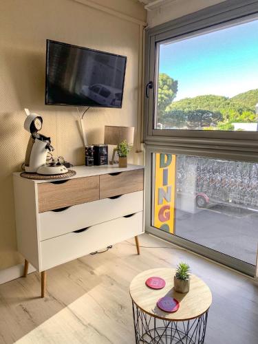 un salon avec une télévision et une table dans l'établissement Le studio de la plage centrale, à Arcachon