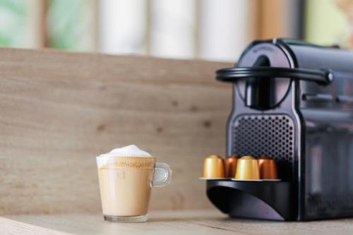 een kop koffie naast een koffiemachine bij Jacuzzi Glass-House Central Station in Krakau