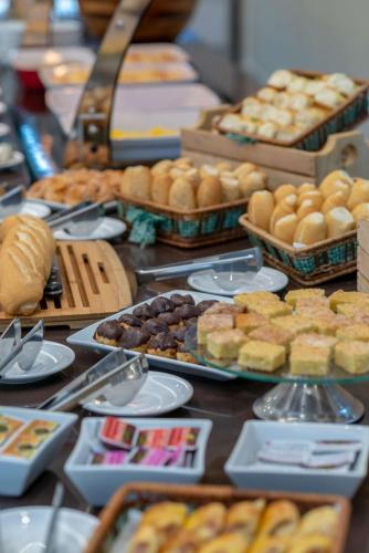 a table topped with lots of different types of pastries at Comfort Suítes Vitória in Vitória