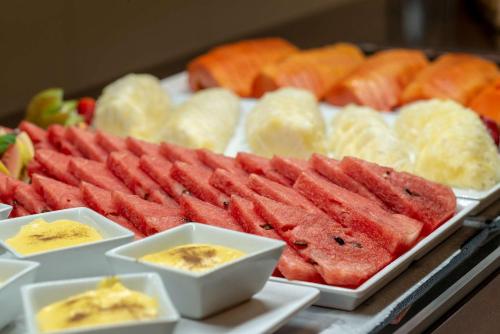 a display of different types of meats and fruit at Comfort Suítes Vitória in Vitória