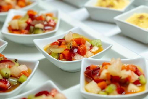 a group of white bowls filled with fruits and vegetables at Comfort Suítes Vitória in Vitória