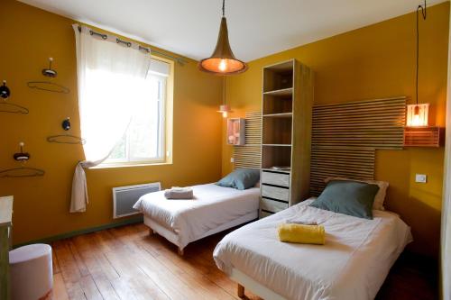 a bedroom with two beds and a window at L'EN VERT in Bagnères-de-Bigorre